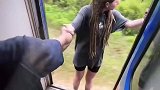 行驶中的火车，男女打开火车门玩起了兜风