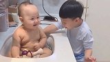 哥哥给弟弟洗澡，没想到水都弄在弟弟脸上了，弟弟反而没有生气！