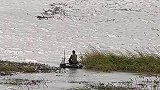 男子借助轮胎在湖上钓鱼