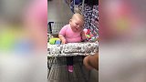 萌娃坐在购物篮里，随着音乐晃动身体，真是太可爱了！