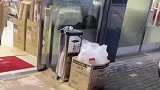 超市门口有雨伞收纳袋，男子见状上前尝试