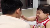 宝贝把爸爸手机给扔了，先是给爸爸做鬼脸，后面竟变成殴打爸爸