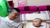 宝宝坐在椅子上，像个小大人，和爸爸玩得很开心