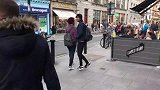 街头草人恶作剧，男子假扮成草人吓路人，街上充满了欢笑