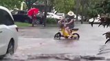 暴雨过后路面积水，男子骑车拉狗子冲浪