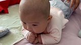 小宝宝在床上练习抬头，看着好难受的样子，接下来的表情太萌了！