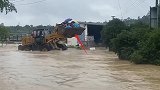 杭州临安暴雨致溪水暴涨漫进民居，多人被困 大型挖掘机涉水救人