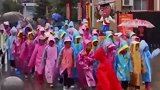 下雨天学生身穿雨衣排队出校门，犹如文武百官散朝一般