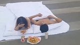 情侣半裸裹床单睡斑马线拍婚纱照 身边来往车辆不断