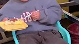 男孩吃蛋糕跷二郎腿，蛋糕踢掉了瞬间笑翻