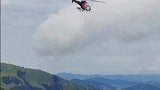 女子在瑞士旅游时拍到直升机空运奶牛下山