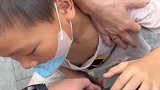 小男孩被男子手表吸引，着迷到家长拉都拉不走