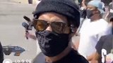 帽子眼镜口罩全副武装 拉塞尔街头参加游行活动拿手机直播