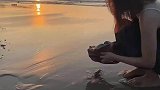 女生日出时放生一只小螃蟹，像极了女孩子提起裙子狂奔