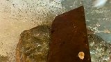 大哥在路边捡来的石头，想用菜刀敲开看里面是什么样的！