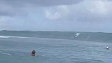 男子在海上冲浪，看见巨浪丝毫不慌