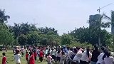 众人进行拔河比赛，男子将绳绑在树上