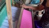 老奶奶用纺织机织布，布料上的纹路逐渐显现