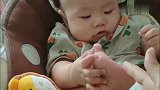 爸爸摸了摸小宝宝的小脚板，接下来宝宝的反应，实在太逗了