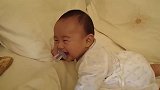 妈妈拍打闹钟，宝宝立马笑眯了眼，都要笑岔气了还不忘嘴里奶嘴
