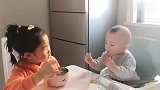 姐姐边给弟弟喂饭，边教训弟弟出门少闯祸，弟弟扭头不吃姐姐的饭