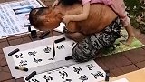 无臂男子在街头写字画摆摊，女儿亲昵地依附在父亲背上