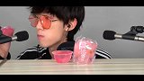 小哥哥戴着粉色眼镜吃粉色的果冻，我猜它是樱花味的