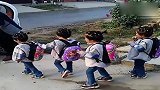 开学了，大力士爸爸拿着四胞胎的被子，送她们上幼儿园