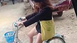 女子骑小孩子的单车，在下坡时重心不稳摔落
