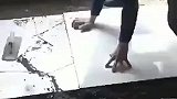师傅用锤子想将瓷砖敲紧实