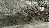 挖掘机被山上巨石砸中，差点砸进驾驶室