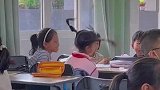 小女孩将辫子甩得飞起，虽然看不到整理，但能感觉很开心