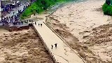 桥上几个人不要命了吧，汹涌洪水涨上桥面，他们还在欣赏风景