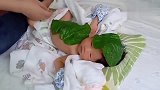 妈妈往新生儿宝宝头上身上贴叶子，这宠爱方式还挺有创意！
