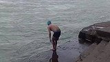 男子在湍急的河流中游泳，路人见状佩服不已
