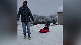 帅哥拉着宝宝滑雪玩，结果一不小心滑板就翻倒了，真逗！