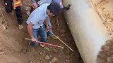 挖掘机将沙土挖走后，淘宝者在土坑中寻宝