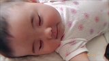 正在睡觉的小宝宝听到妈妈的声音，竟笑到停不下来