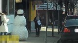 美女悠闲漫步街道，似乎没有注意到，前方的大雪人有些不同！