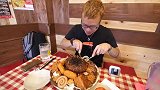 小哥吃肉饼、炸猪排和香肠，这些肉堆成一座小山，食量真大