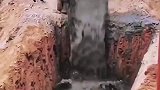 卡车正在不断的将水泥浆倒进巨型深坑里