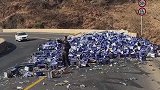 啤酒堆积在山路上，男子拿起一瓶直接喝