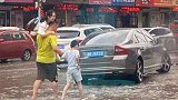 辽宁鞍山：暴雨积水，爸爸左手扛起妈妈右手牵儿子趟水过街