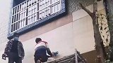 男子在墙上锯开一个洞，从里面掏出一包好东西