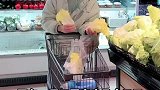 男生陪对象逛超市，边逛边择菜。