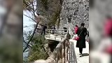 陕西一男子半身悬空挂在景区栈道外 景区：估计是为了拍照