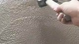 工人用锤子，在水泥浆上写字