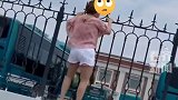 道路积水女子攀爬在围墙上行走