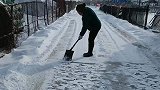 老人自发清理路面积雪