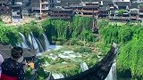 两美女在吊脚楼房顶听瀑布